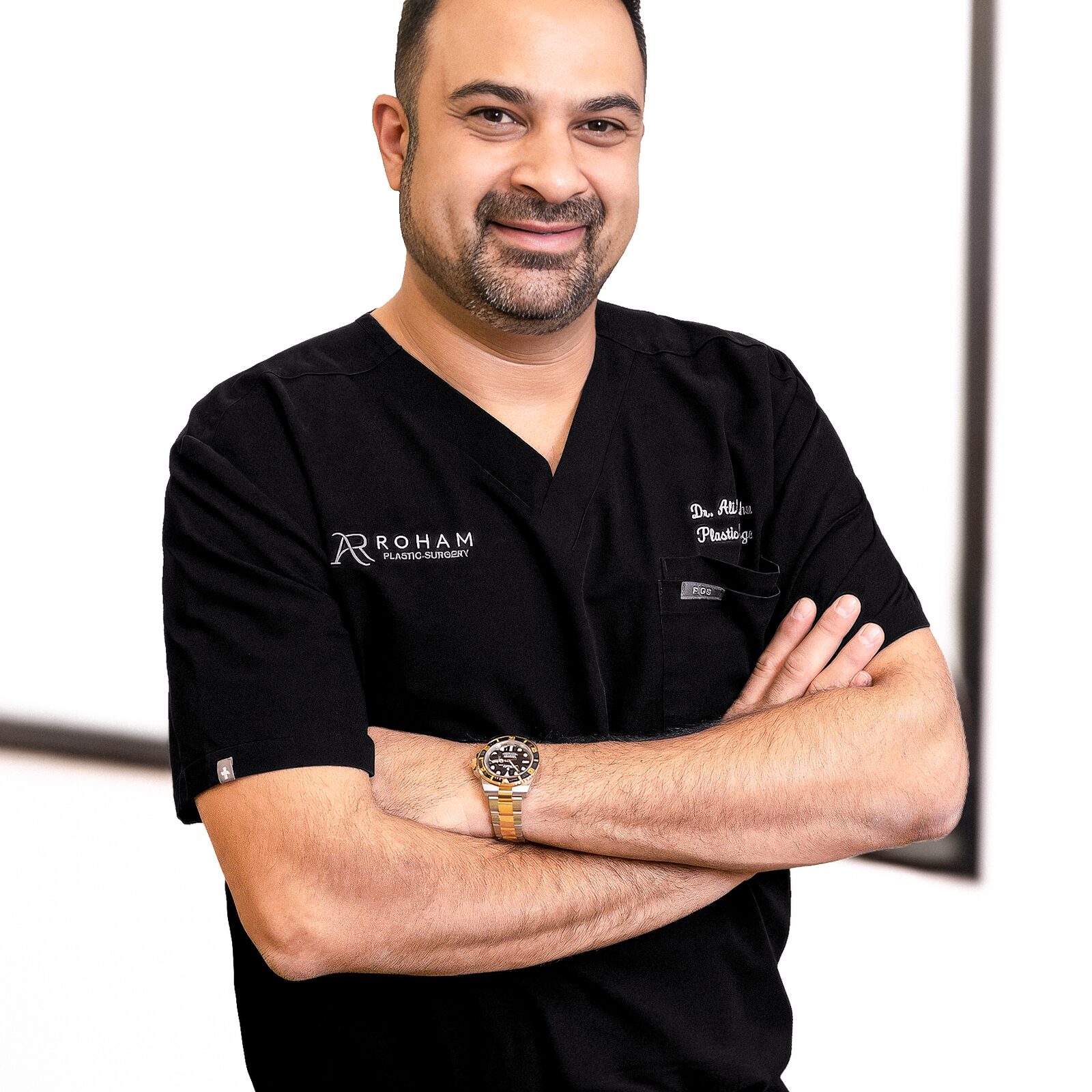 Dr. Ali Roham in black scrubs with his arms crossed